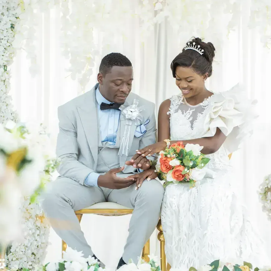 Bride and groom sitting under a floral arch