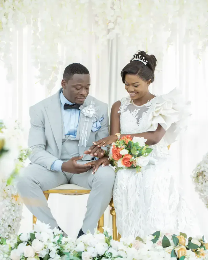 Bride and groom sitting under a floral arch