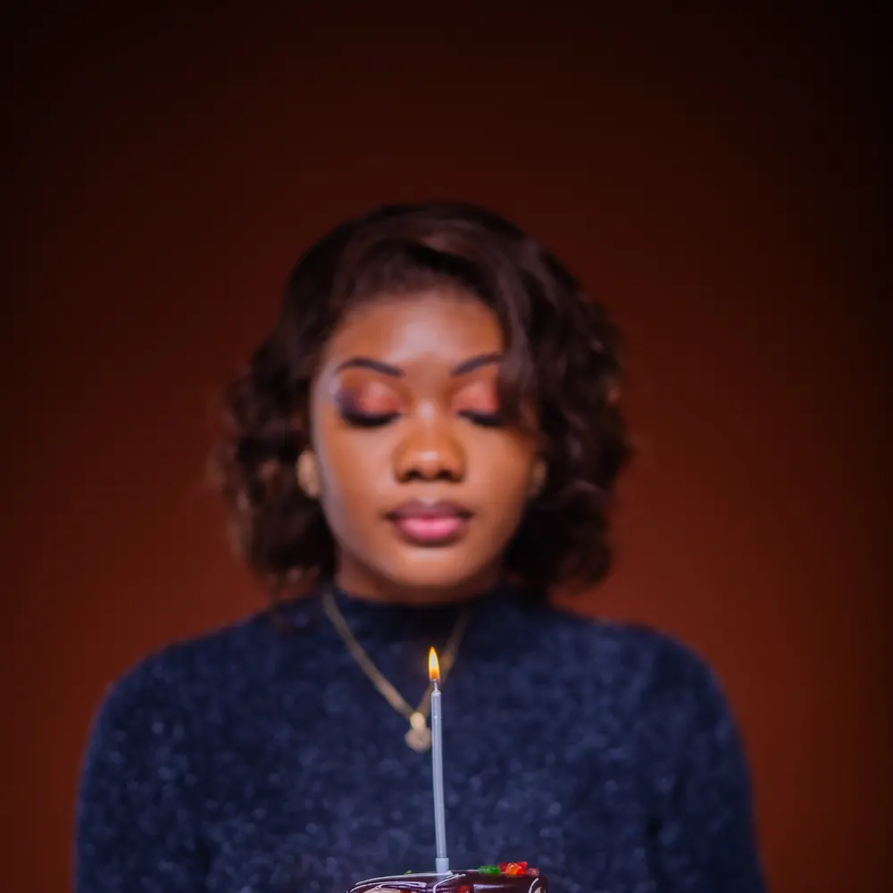 Portrait d’une jeune femme tenant un gâteau et sa bougie, photographie L21STUDIOS