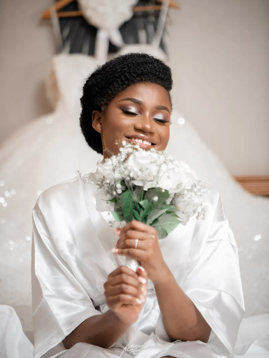 Mariée en peignoir tenant son bouquet pendant les préparatifs, photographie L21STUDIOS