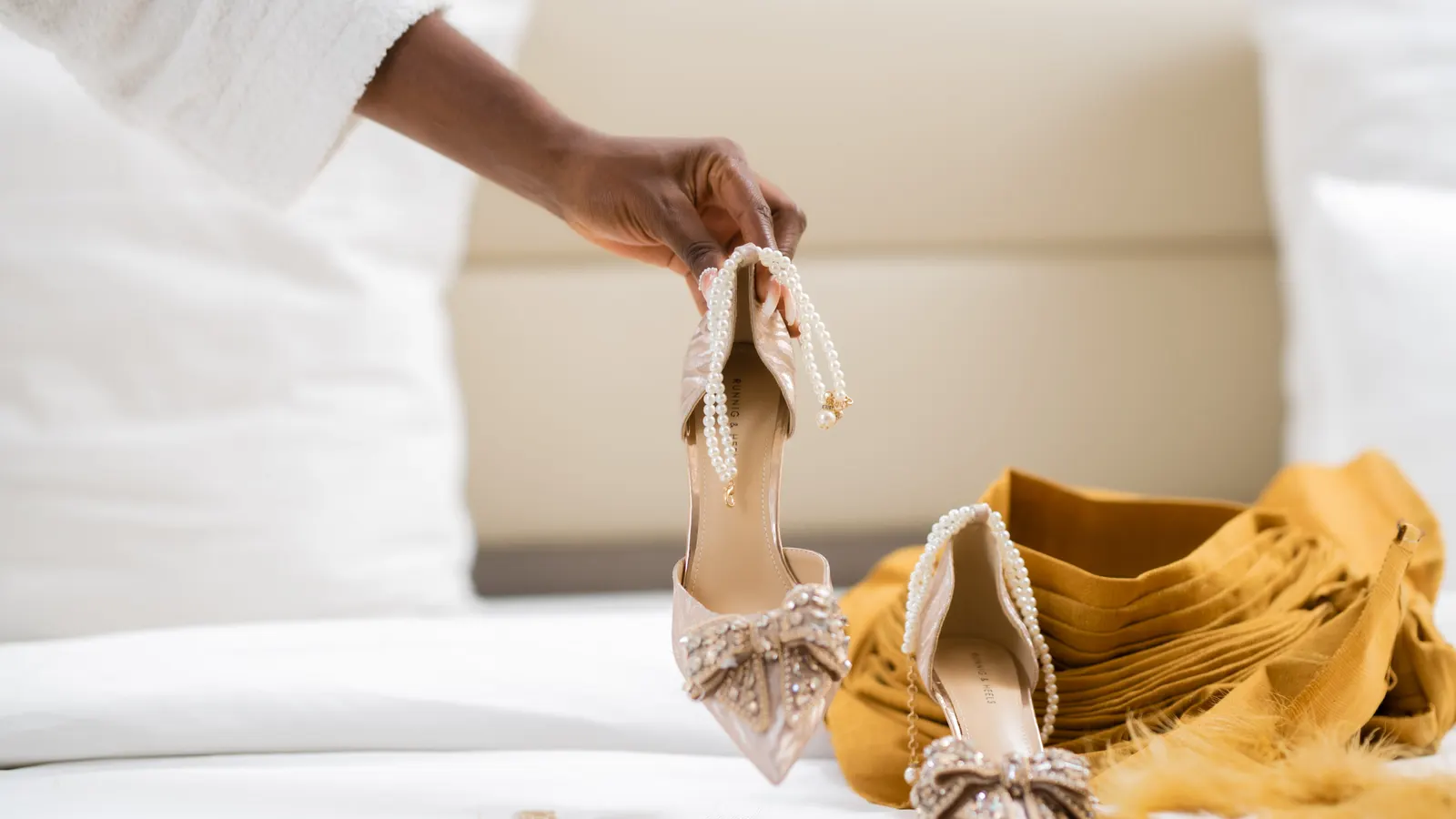 Souliers de la mariée posés sur le lit, photographie L21STUDIOS